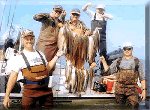 Captain Leaf Potter and guests proudly show off an impressive stringer of redfish and speckled trout